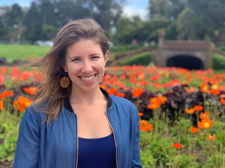 photo of alison zuba and orange poppy flowers in the background